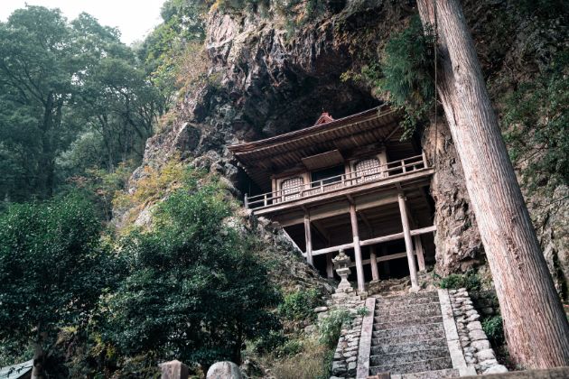 不動院岩屋堂 鳥取県八頭郡若桜町岩屋堂 建物全体が天然の岩洞にすっぽり収まった「不動院岩屋堂」は、約600年前に建立されたといれる舞台造りの密教建築物。「窟堂」ともいわれ、国の重要文化財に指定されています。日本三大投入堂のひとつで、パワースポットとしても有名。日本三大不動明王のひとつでもあり、毎年3月と7月の護摩法要の際に一般公開されます。