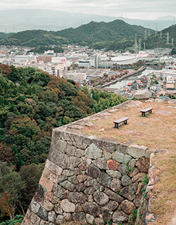 米子城跡 ベンチ よなごじょうあと かつては四層五重の天守閣を誇った、山陰随一の名城跡。立派な石垣が当時の面影を残します。現在は360 度の大パノラマで米子市街を見渡せる、米子屈指の絶景スポットに。標高90m の天守からは、北遠方に雄大な日本海の水平線、西に真っ青な中海、東遠方に名峰大山の姿が望めます。また、桜の名所としても愛されています。鳥取県米子市久米町