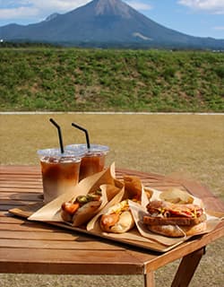 テラス ザ ダイセン ランチ『大山(だいせん)ハム』の新工場「大山工場」の直売所&テイクアウトショップ。雄大な大山を仰ぎ見る絶好のロケーションにあり、『大山ハム』こだわりの熟成シリーズをはじめとするハム・ソーセージを種類も豊富に提供。テイクアウトで、できたてのジューシーなホットドッグや焼きソーセージ、スイーツやドリンクなどが味わえます。鳥取県西伯郡伯耆町須村