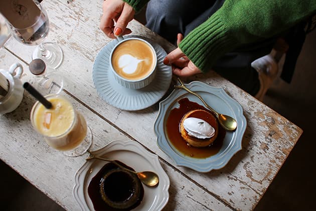 Goods&Café みっくす コーヒー、プリン、ジュース、カフェラテ、店内、グッズアンドカフェミックス 米子市の商店街にある築100年以上の薬局をリノベーションしたカフェ。梁や土壁をそのまま活かした趣のある空間です。こちらで人気のパフェは、季節ごと、年中のイベントごとに変わり、期間限定で登場。目でも舌でも楽しめる絶品・映えスイーツです。ほかに、昔ながらの硬めのプリンやミックスジュース、元々まかないメニューだったものがスタッフから好評でメニューに追加されたビビンバもおすすめ。鳥取県米子市日野町