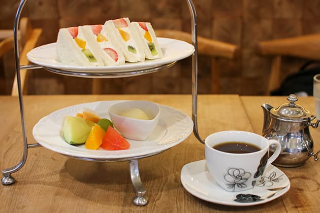 フルーツカフェサエキ サンドウィッチとフルーツ、コーヒー店内の様子『米子市美術館』併設の『フルーツカフェサエキ』。季節のフルーツがたっぷり楽しめるモーニングやブランチのセットメニューのほかに、フルーツサンドやパフェなどのスイーツや100%フレッシュジュースなどが味わえます。向かいには『米子市立図書館』もあり、芸術や文化にふれながらフルーツをぜいたくに楽しめるカフェです。⿃取県米子市中町